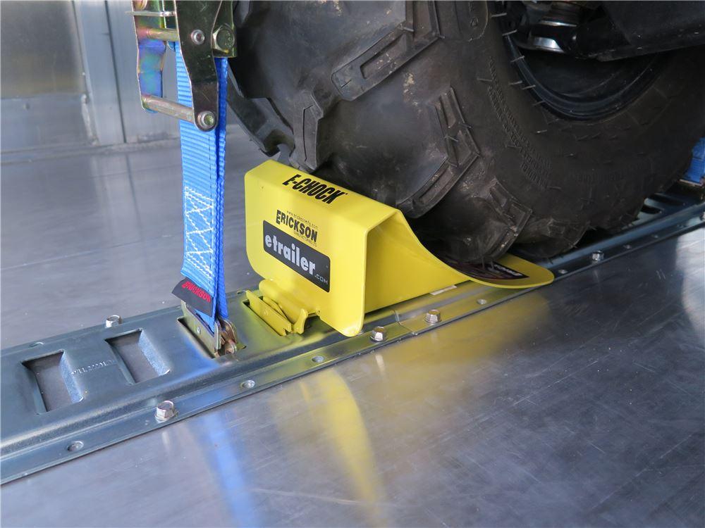 E Track wheel chock securing a motorcycle tire inside a trailer
