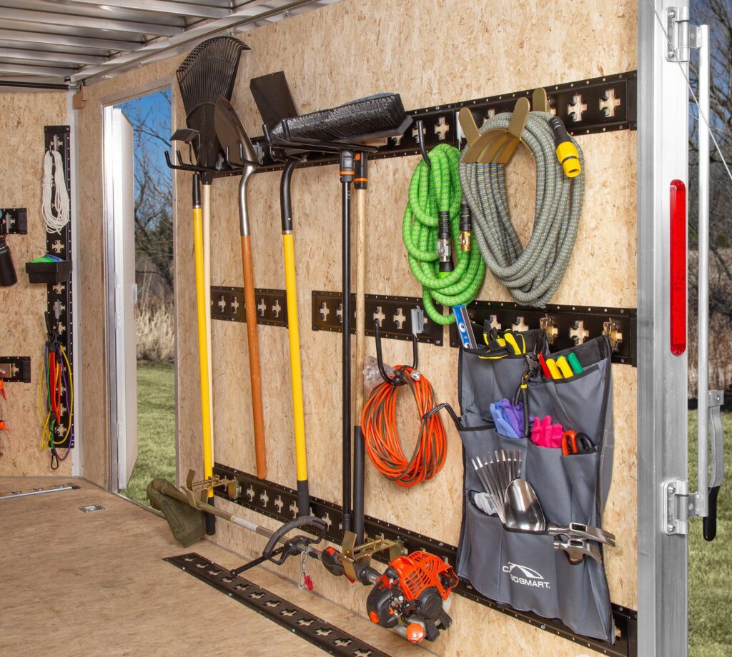E Track storage hooks organizing straps and tools inside a trailer