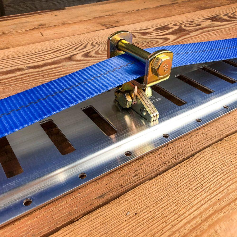 E Track idler assembly guiding a cargo tie down strap