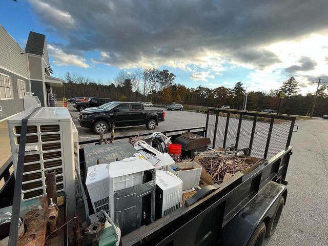 Scrap steel, old washing machines, dryers, metal shelving, or similar recyclable items inside a dump trailer.